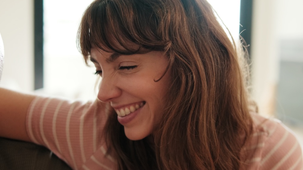 Woman laughing while relaxing at home